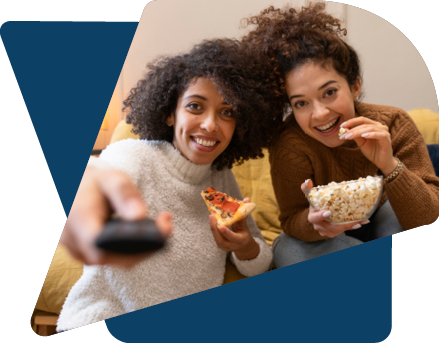 Two females watching television with popcorn